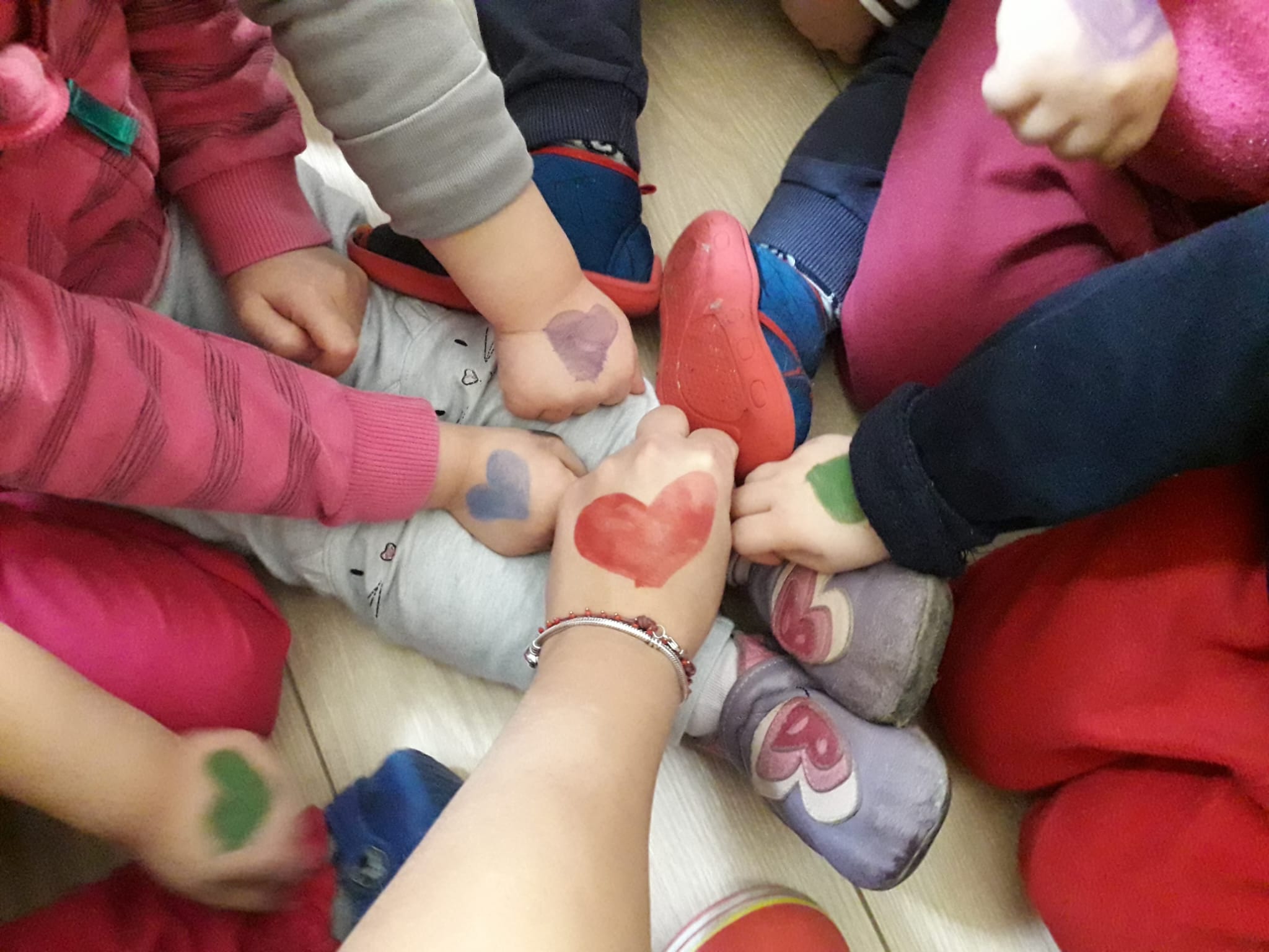 Mani di bambini con cuori colorati disegnati