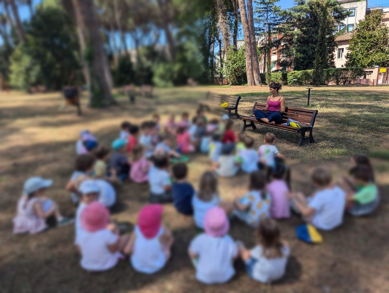 Cerchio di bambini nel prato durante un'attività all'aperto